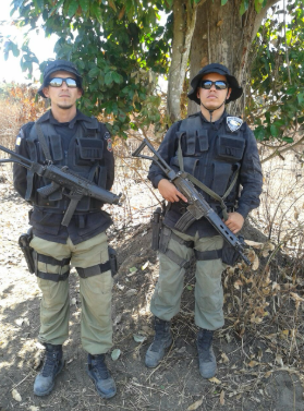 Dois homens fardados e equipados em serviço militar.