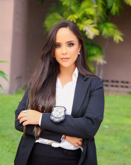 Mulher vestida com roupa social usando um distintivo.